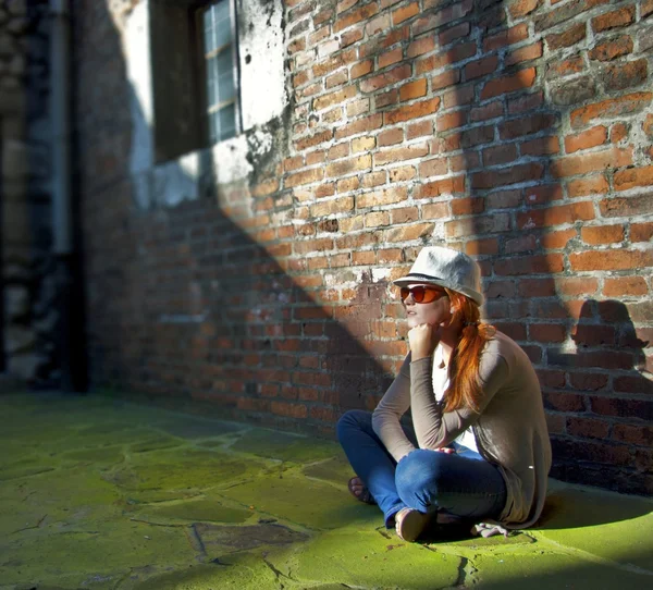Dreaming pretty woman with white hat in a romantic alley — Stock Photo, Image