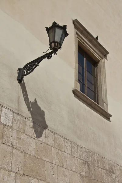Oude muur met venster en lamp — Stockfoto