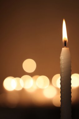 White candle on dark background clipart