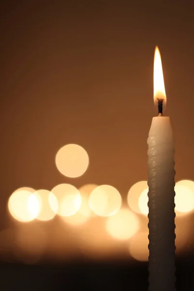 Weiße Kerze auf dunklem Hintergrund Stockfoto