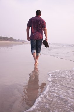mal deniz kenarında yürüyen adam