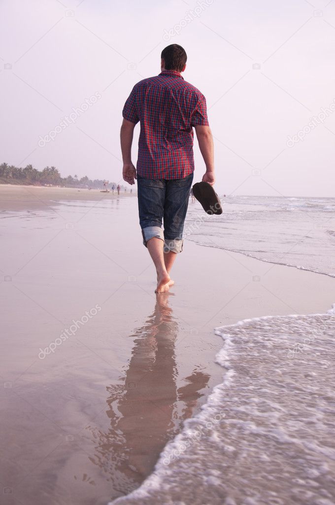 Man walking along the sea cost