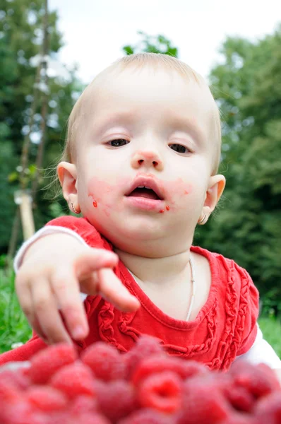 Year-old girl eating raspberries — Stock Photo, Image