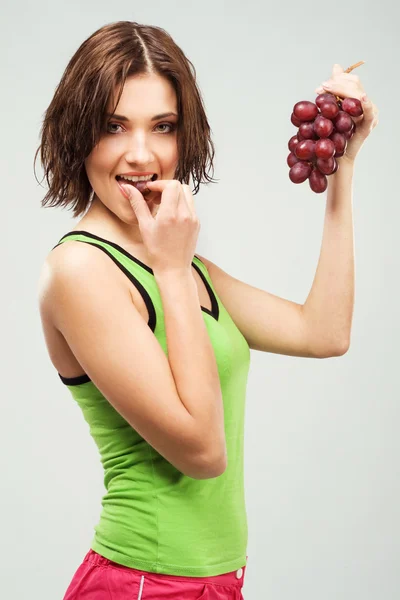 Mulher desportiva bonita comendo uvas — Fotografia de Stock