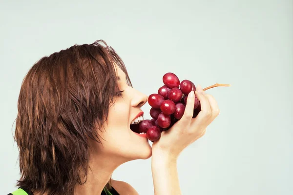 Piękna kobieta jedzenie winogron — Zdjęcie stockowe