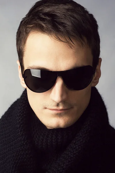 Bello uomo in occhiali da sole e sciarpa nera — Foto Stock