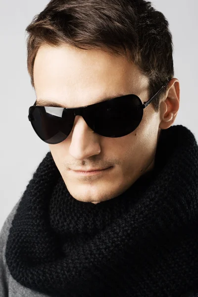 Hombre guapo en gafas de sol oscuras y bufanda negra — Foto de Stock
