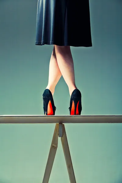 Schlanke weibliche Beine auf dem Tisch gekreuzt Stockbild
