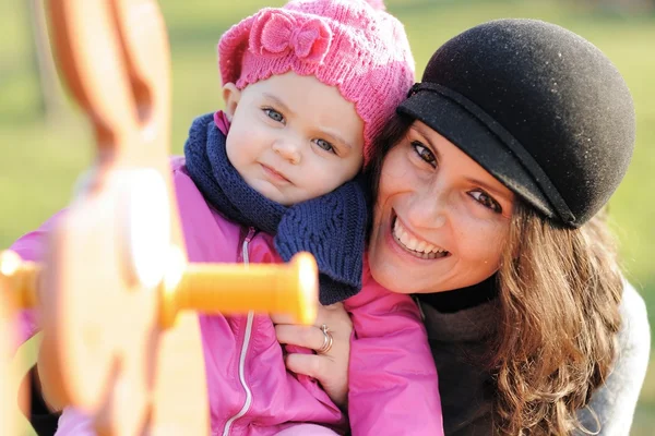 stock image Smiling mother and child playing on the swing