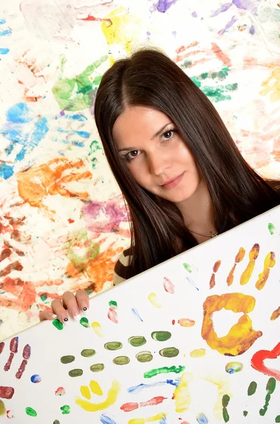 Дівчина з рукою, пофарбована в барвисті фарби, готові для відбитків рук — стокове фото