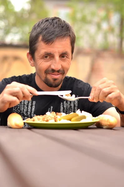 Portrait of a man eating outdoor — Stock Photo, Image