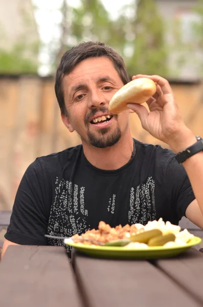 Портрет человека, который ест на открытом воздухе — стоковое фото