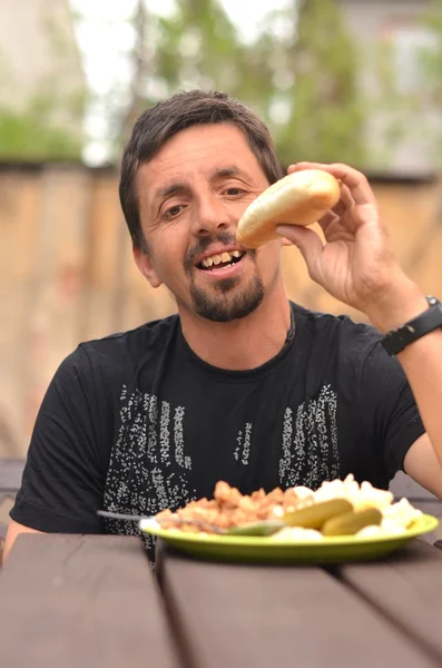 Portrait of a man eating outdoor — Stock Photo, Image