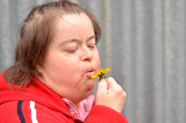 ダウン症候群の女性吹くタンポポ — ストック写真