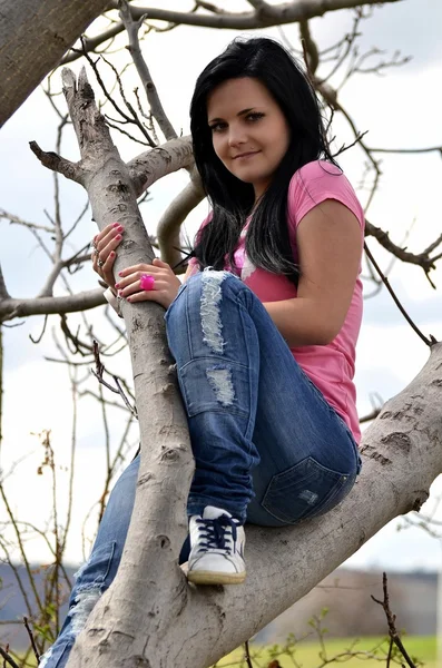 Flicka sitter tillbaka på träd — Stockfoto