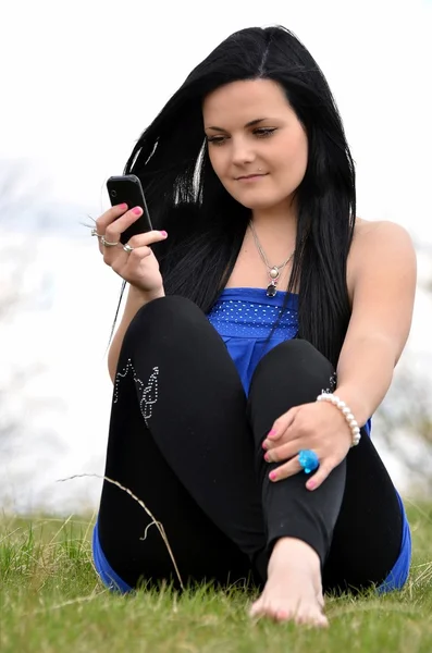 Aantrekkelijk meisje op de natuur met mobiele telefoon — Stockfoto