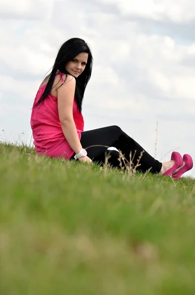 Aantrekkelijk meisje op een veld in het voorjaar van — Stockfoto