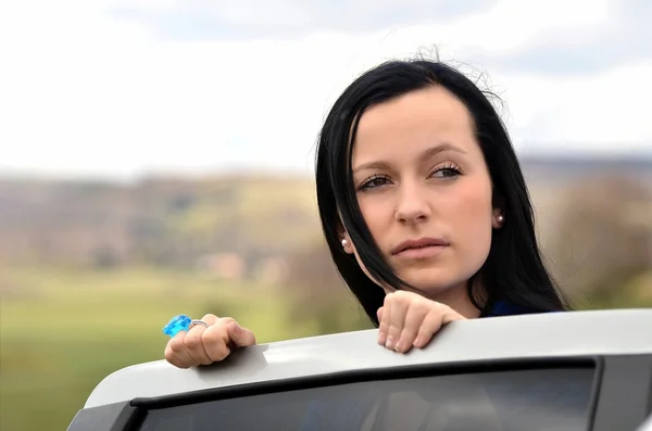 Brünette Frau steht neben Auto — Stockfoto