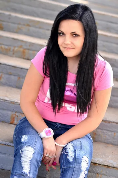 Uma linda adolescente sentada nos degraus da arquibancada — Fotografia de Stock