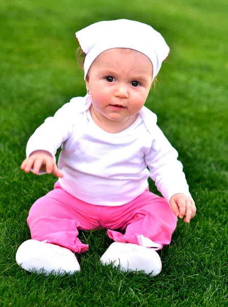 Glückliches Baby auf Gras sitzend — Stockfoto