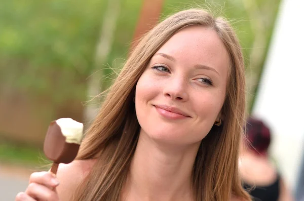 Portrait of a beautiful young woman holding a delicious ice cream in hand — Stock Photo, Image