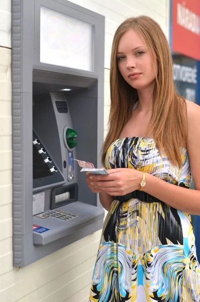 Femme retirant de l'argent de la carte de crédit au guichet automatique. — Photo