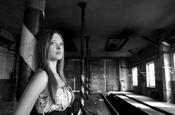 Jonge vrouw in oude fabriek — Stockfoto