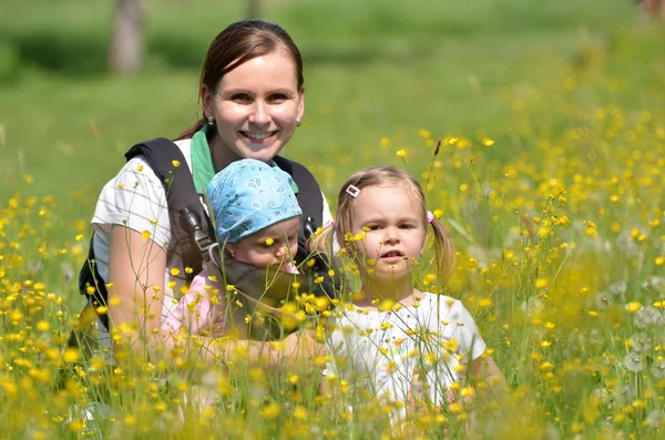 Mother with her two daughters on meadow — Stock Photo, Image