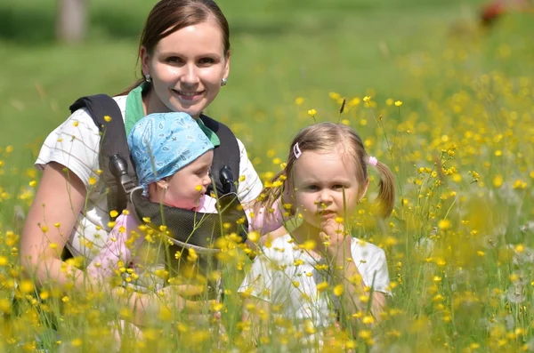 Mother with her two daughters on meadow — Stock Photo, Image