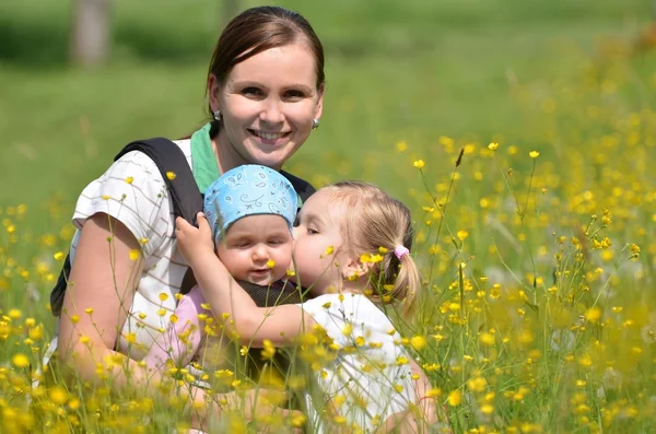 Madre con sus dos hijas en el prado — Foto de Stock