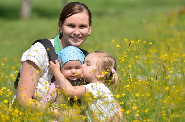 Mutter mit ihren beiden Töchtern auf der Wiese — Stockfoto