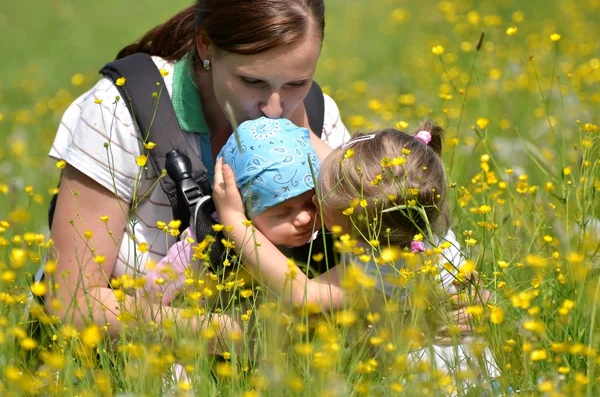 Mamma med hennes två döttrar på äng — Stockfoto