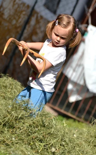 Dziecko dziewczynka gra z cięcia trawy — Zdjęcie stockowe
