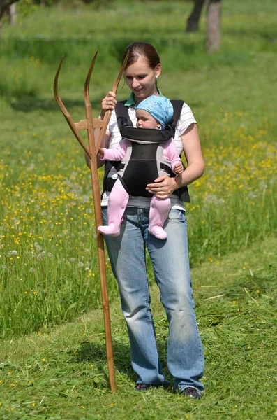Junge Mutter mit Kind bei der Gartenarbeit — Stockfoto