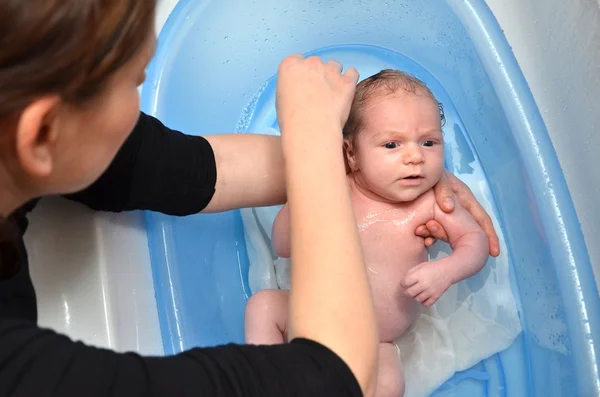 初生婴儿浴在蓝色浴缸由母亲 — 图库照片