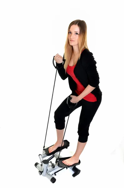 Mujer joven haciendo ejercicio en stepper trainer, vertical — Foto de Stock