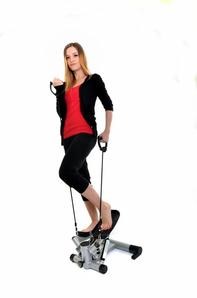 Young woman exercising on stepper trainer, vertical — Stock Photo, Image