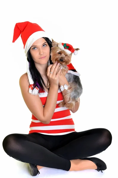 Söt flicka och hund i santa hatt vid jul — Stockfoto