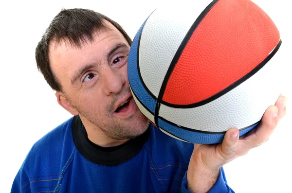 Человек с синдромом Дауна играет с баскетболом на белом фоне — стоковое фото