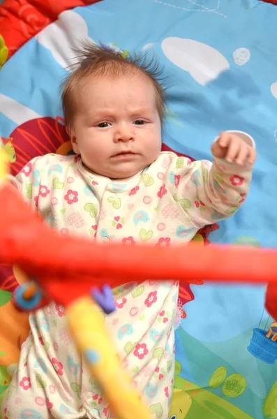 Happy baby playing in baby gym toy — Stock Photo, Image