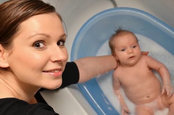 Μπάνιο νεογέννητο μωρό στο μπλε μπανιέρα από μητέρα — Φωτογραφία Αρχείου