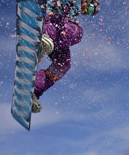 Snowboarder στο άλμα στα ψηλά βουνά την ηλιόλουστη μέρα. — Φωτογραφία Αρχείου