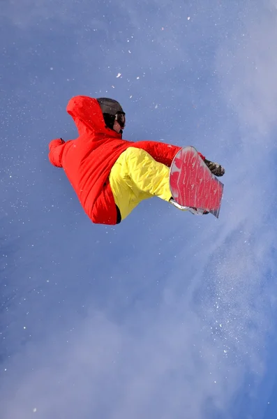 Snowboardåkare hoppar i höga berg på solig dag. — Stockfoto