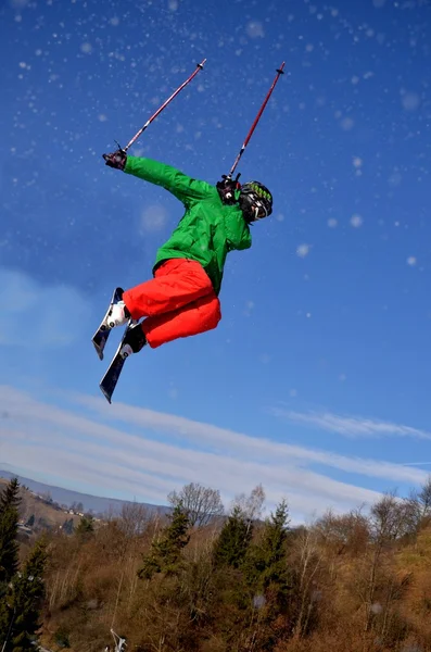 Esquiador en salto en las altas montañas en el día soleado . — Foto de Stock