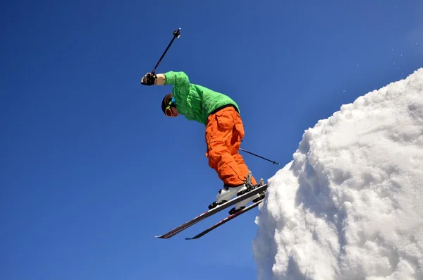 Lyžař na skok inhigh hory na slunečný den. — Stock fotografie
