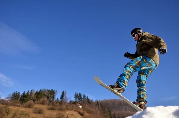Güneşli bir günde yüksek dağlara atlayan snowboardcu.. — Stok fotoğraf