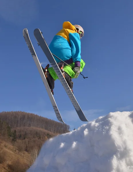 Skier at jump inhigh mountains at sunny day. — Stock Photo, Image