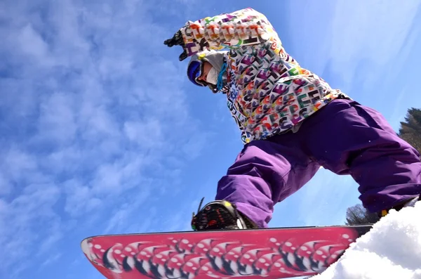 Snowboarder en salto inhigh montañas en día soleado. —  Fotos de Stock