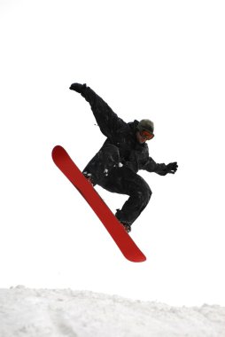 Güneşli bir günde yüksek dağlara atlayan snowboardcu..