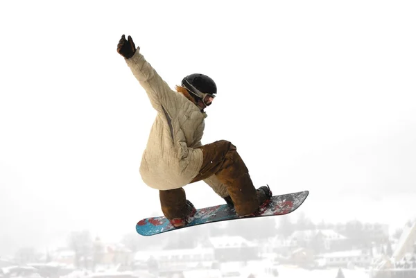 Snowboarder au saut enhaute montagne à la journée ensoleillée. — Photo